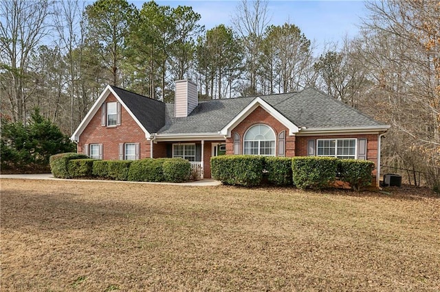 view of front of property featuring cooling unit and a front yard