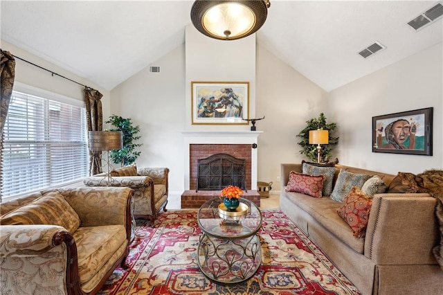 living area featuring visible vents, a brick fireplace, and high vaulted ceiling