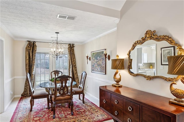 dining space with ornamental molding, a chandelier, sink, and a textured ceiling