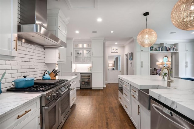 377 Camden Rd NE, Atlanta, GA 30309 - kitchen with stainless steel appliances, beverage cooler, wall chimney range hood, white cabinets, and pendant lighting