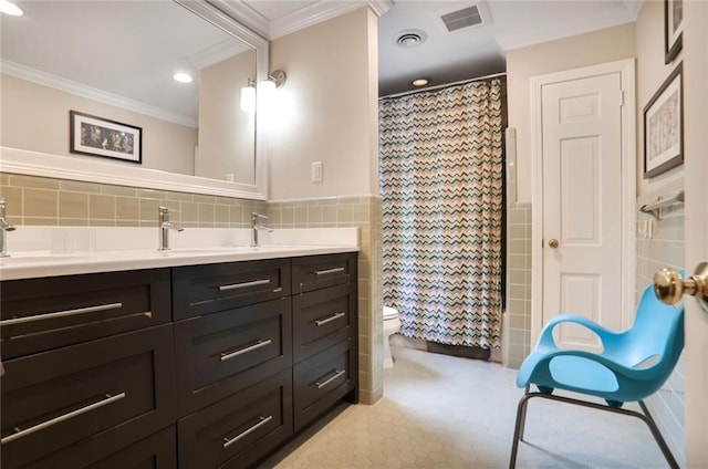 377 Camden Rd NE, Atlanta, GA 30309 - full bathroom with tile walls, double vanity, crown molding, recessed lighting, and wainscoting