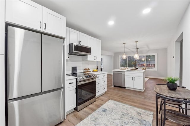 kitchen featuring light wood-style floors, appliances with stainless steel finishes, white cabinets, and light countertops