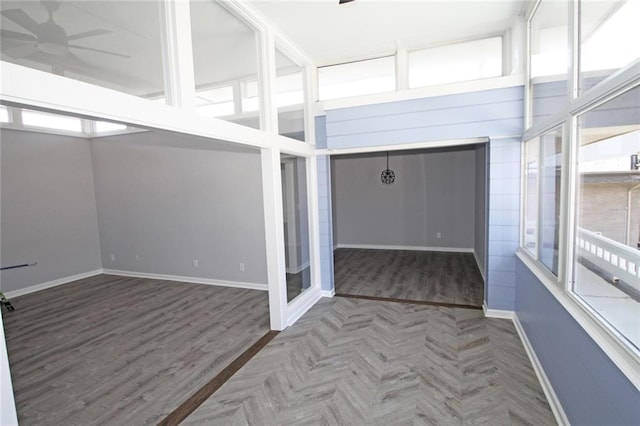 unfurnished sunroom with a ceiling fan