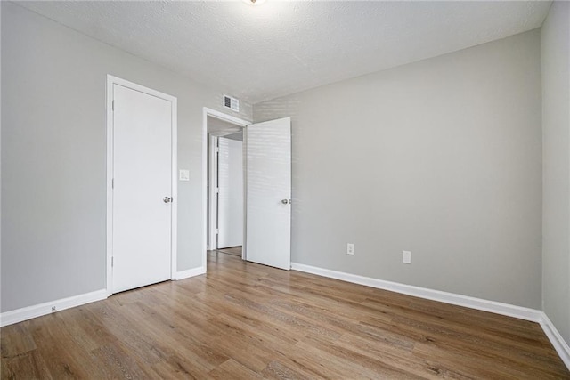 interior space with wood finished floors, visible vents, and baseboards