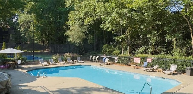 community pool featuring fence and a patio area