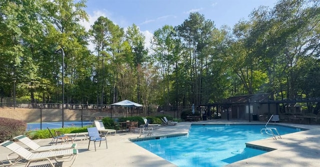 community pool featuring fence and a patio area