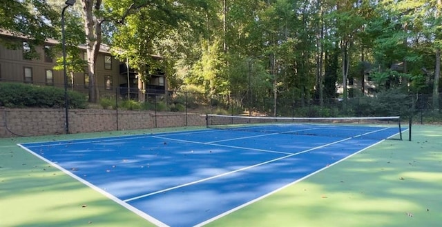view of tennis court featuring fence