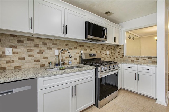 kitchen featuring a sink, decorative backsplash, visible vents, white cabinetry, and appliances with stainless steel finishes