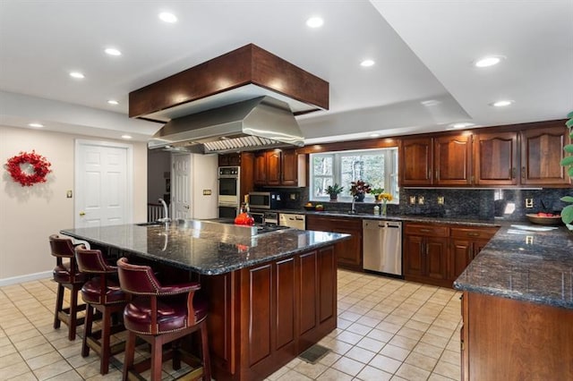 kitchen featuring a large island, appliances with stainless steel finishes, light tile patterned floors, dark stone countertops, and island range hood