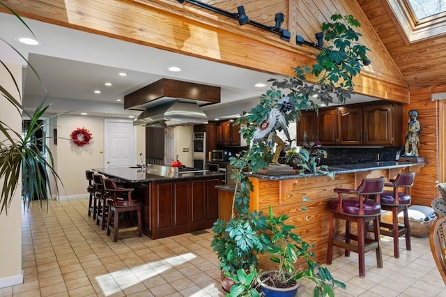 kitchen featuring wooden ceiling, light tile patterned flooring, and lofted ceiling with skylight