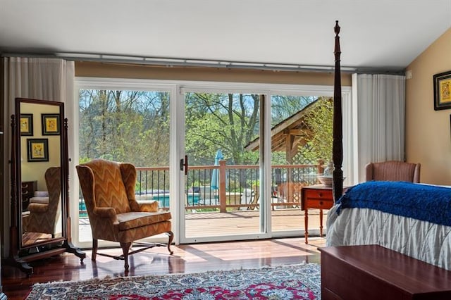 bedroom featuring hardwood / wood-style flooring, access to exterior, and vaulted ceiling