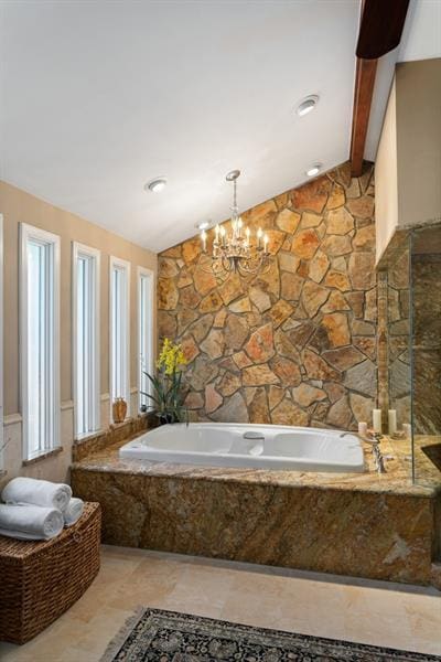 bathroom featuring a relaxing tiled tub and lofted ceiling with beams