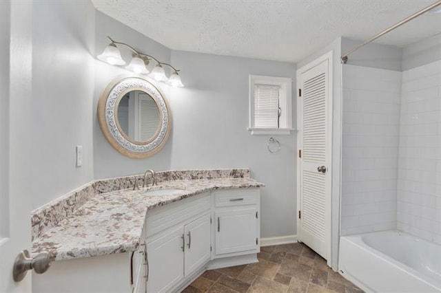 bathroom with vanity, a textured ceiling, and shower / bathing tub combination