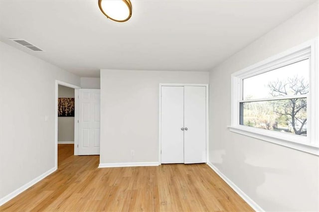 unfurnished bedroom featuring a closet and light hardwood / wood-style floors