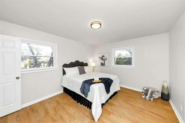 bedroom with multiple windows and hardwood / wood-style flooring