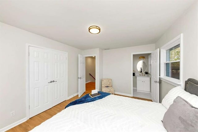 bedroom with hardwood / wood-style flooring, ensuite bath, and a closet