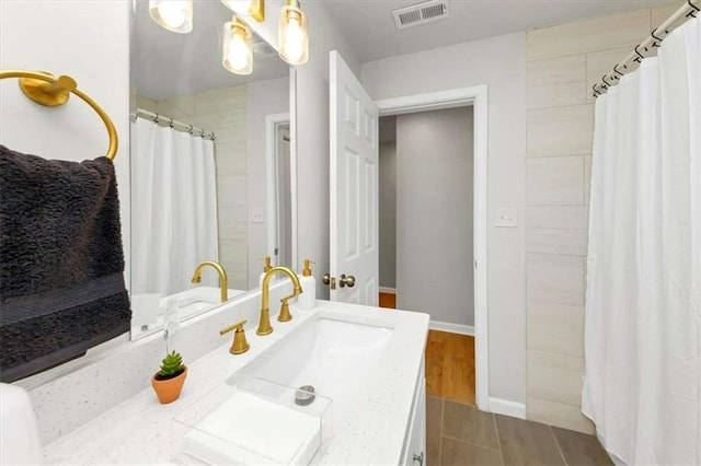 bathroom with wood-type flooring, vanity, and walk in shower