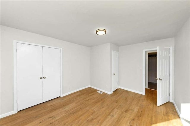 unfurnished bedroom featuring light hardwood / wood-style floors and a closet