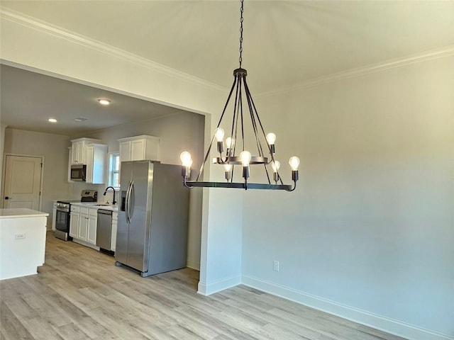 228 Trellis Walk, Macon, GA 31220 - kitchen with appliances with stainless steel finishes, a chandelier, white cabinets, light wood-type flooring, and ornamental molding