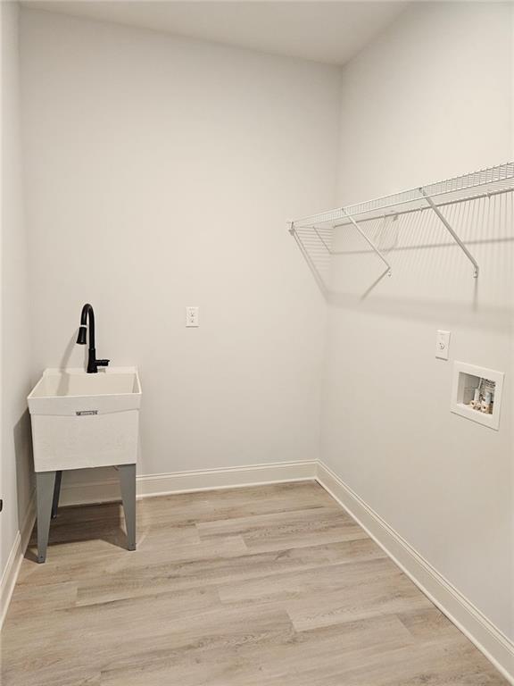228 Trellis Walk, Macon, GA 31220 - clothes washing area featuring washer hookup, baseboards, and light wood-style floors