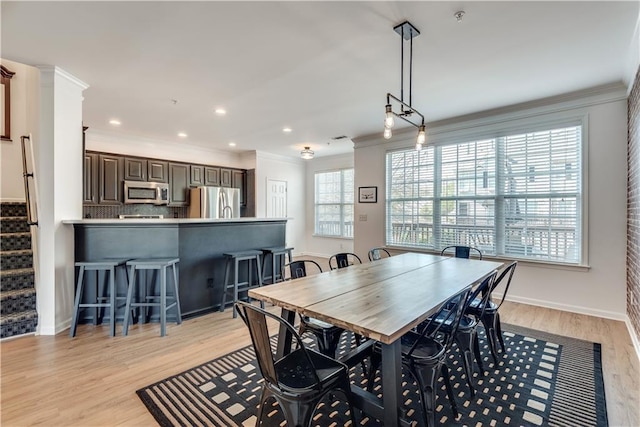 dining room featuring light hardwood / wood-style flooring and ornamental molding