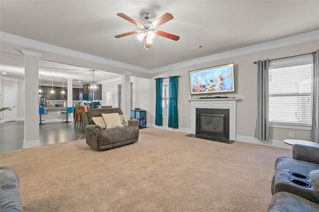 living room with ceiling fan with notable chandelier, carpet floors, and ornamental molding