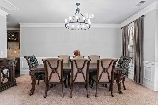 dining area with light carpet, ornamental molding, and a chandelier