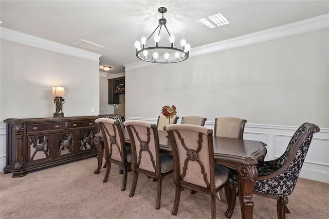 dining area featuring light colored carpet, crown molding, and a chandelier