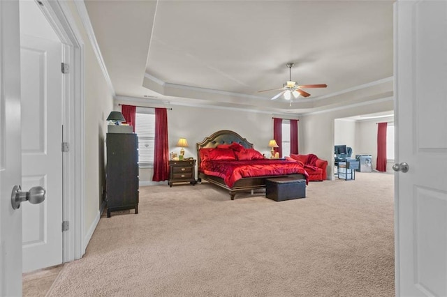 bedroom with a raised ceiling, ceiling fan, light carpet, and multiple windows