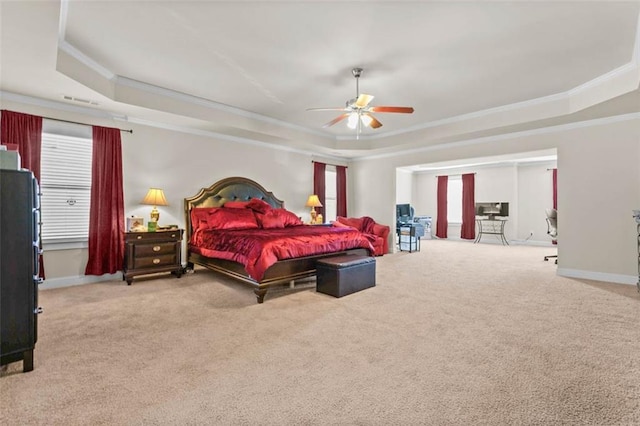 carpeted bedroom featuring ceiling fan, ornamental molding, and a tray ceiling