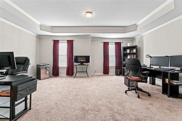 carpeted home office featuring ornamental molding and a raised ceiling