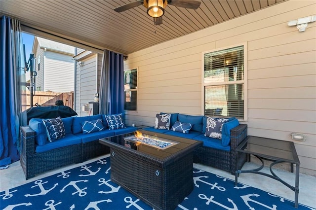 view of patio / terrace with ceiling fan and an outdoor living space with a fire pit