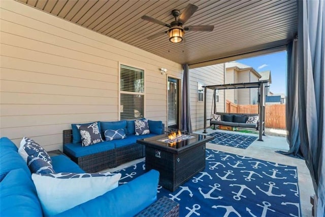 view of patio featuring ceiling fan and an outdoor living space with a fire pit