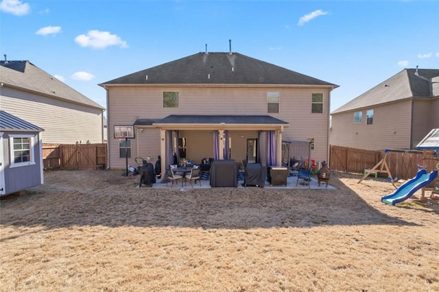 back of house with a playground and a patio