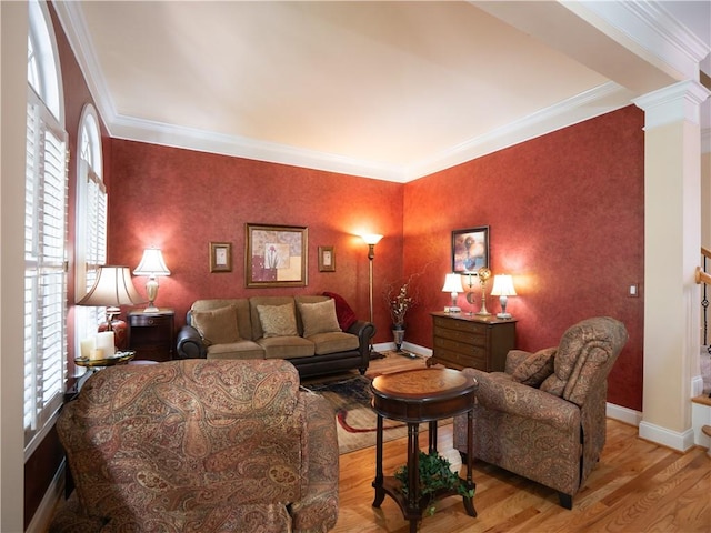 living room with ornamental molding, decorative columns, and light hardwood / wood-style floors