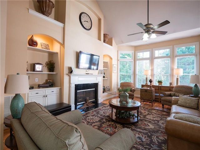 living room featuring hardwood / wood-style floors, ceiling fan, high vaulted ceiling, and built in shelves