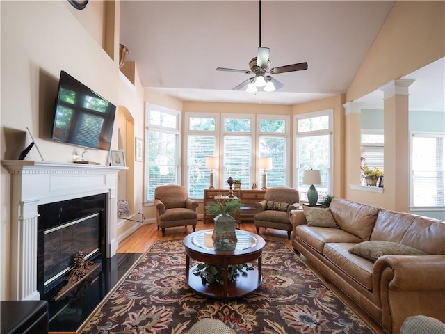 living room with lofted ceiling, hardwood / wood-style floors, decorative columns, and ceiling fan