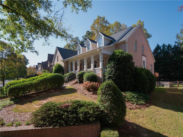 view of home's exterior with a yard and a porch