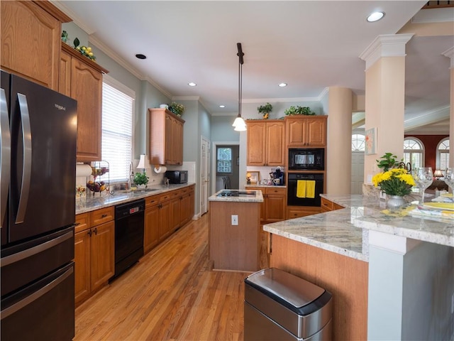 kitchen with light hardwood / wood-style floors, crown molding, black appliances, and a center island