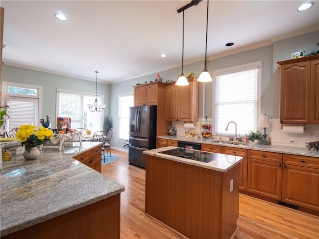 kitchen featuring plenty of natural light, sink, a center island, and refrigerator with ice dispenser