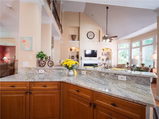 kitchen featuring kitchen peninsula, hardwood / wood-style floors, light stone countertops, and ceiling fan