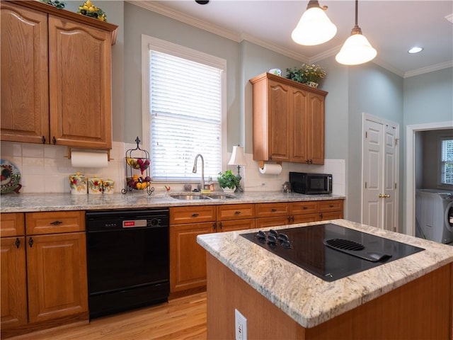 kitchen with light stone countertops, light wood-type flooring, black appliances, pendant lighting, and sink