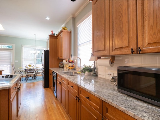 kitchen featuring plenty of natural light, sink, light wood-type flooring, and refrigerator