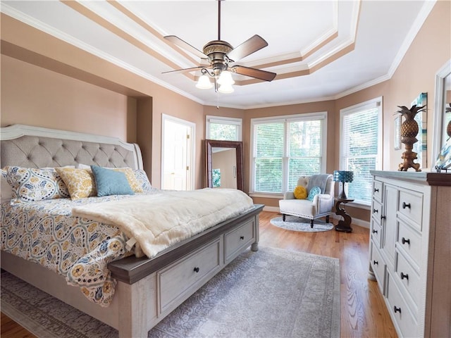 bedroom featuring crown molding, light wood-type flooring, and ceiling fan