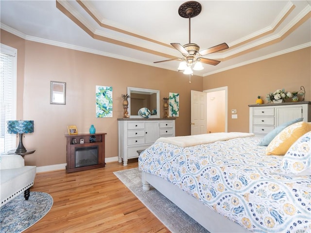 bedroom featuring ornamental molding, a raised ceiling, light hardwood / wood-style floors, and ceiling fan