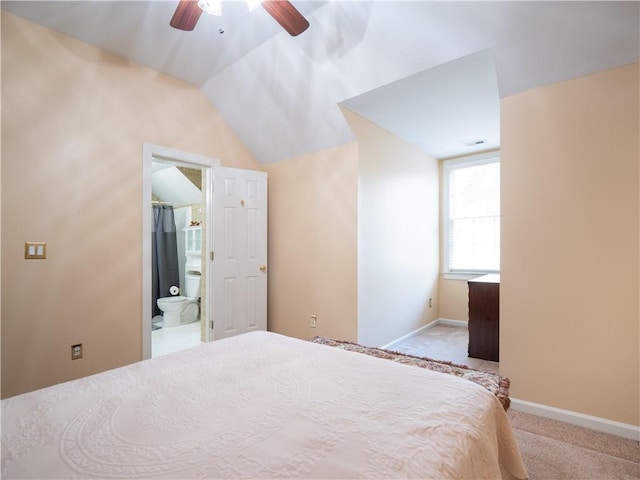 unfurnished bedroom featuring lofted ceiling, ensuite bathroom, light colored carpet, and ceiling fan