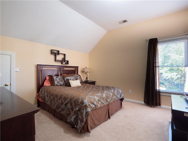 bedroom featuring light carpet and vaulted ceiling