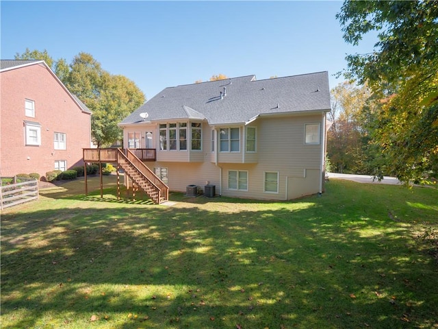 rear view of house with a yard, a deck, and central air condition unit