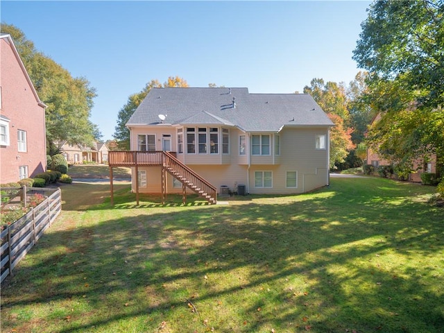 back of house with a wooden deck, cooling unit, and a lawn