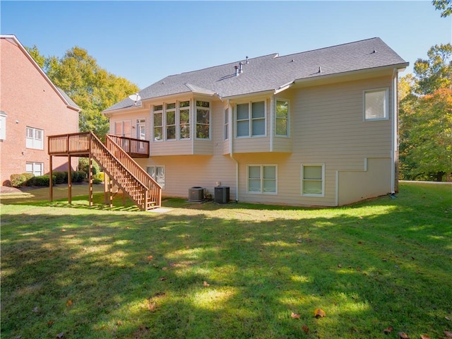 back of property with a wooden deck, a lawn, and central AC unit